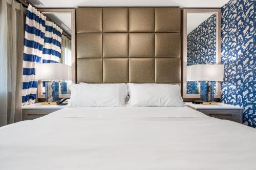 土桑3 Palms Tucson North Foothills的卧室配有一张白色大床和两盏灯。