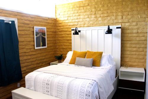 塞多纳The Three Keys duplex的一间卧室配有白色床和黄色枕头