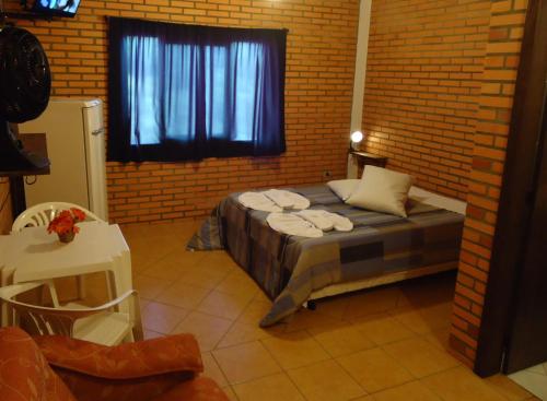 圣弗朗西斯科-迪保拉Pousada Parque da Cachoeira的卧室配有砖墙内的床铺
