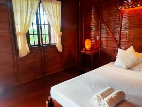 锡基霍尔Winyanz Tambayan Tourist Inn的一间卧室配有带毛巾的床
