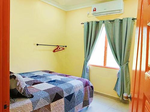 莎阿南Hanani Homestay的一间卧室设有一张床和一个窗口