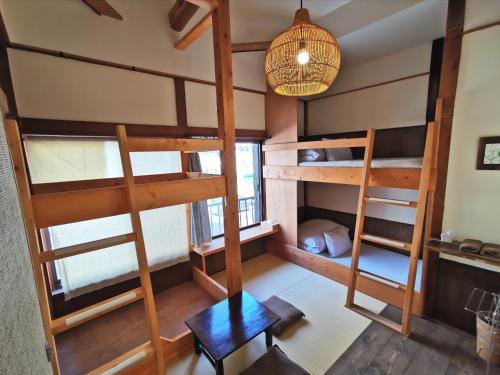 东京小松旅馆的客房设有双层床、桌子和台灯。