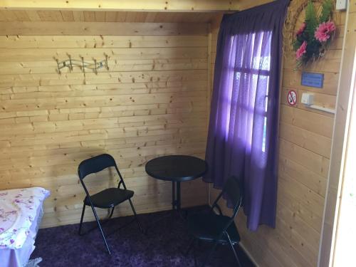 派尔努园中屋度假公园的一间设有两把椅子、一张桌子和一个窗户的房间