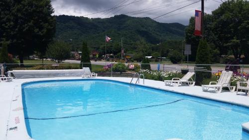 马吉谷假日汽车旅馆-马吉谷的一个带椅子的大型蓝色游泳池和山脉
