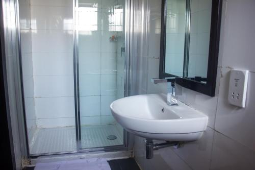 拉各斯S & S Hotel & Suites的白色的浴室设有水槽和淋浴。