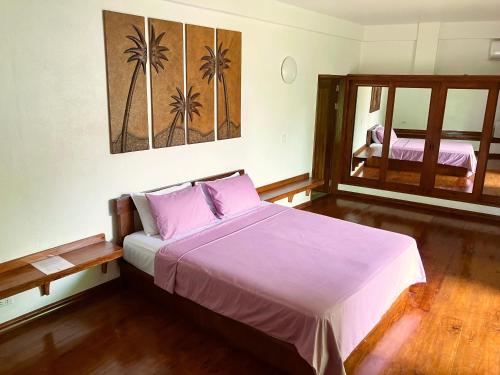 邦劳Villa Formosa Panglao的一间卧室配有一张带紫色床单的床和窗户。