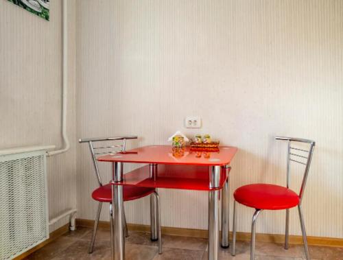 基辅Apartment with a panoramic view of Podil near the metro的客房内的一张红色桌子和两把椅子