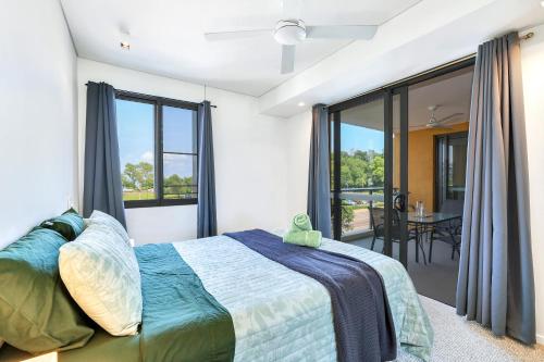达尔文Cute & Cosy Darwin Waterfront Apartment with Queen Bed的一间卧室设有一张床和一个大窗户