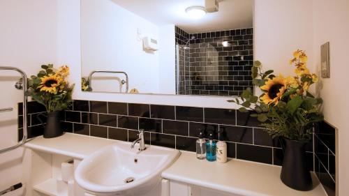 南安普敦SOUTHAMPTON Central Apartments - Wise Stays的浴室设有水槽、镜子和鲜花