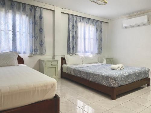 琅勃拉邦Khonesavane Hostel的一间卧室设有两张床和两个窗户。