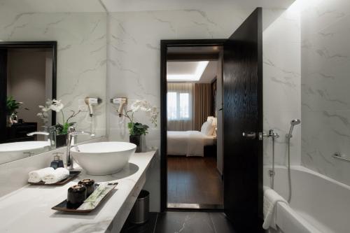 河内PALAGO BOUTIQUE HOTEL的浴室配有盥洗盆、浴缸和浴缸。