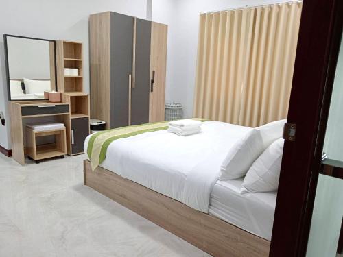 Ban Khlong WaPause Homestay的卧室配有白色的床和镜子