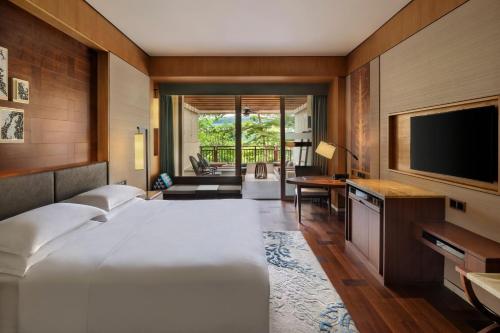 景洪市西双版纳喜来登大酒店的一间卧室配有一张大床和一台平面电视