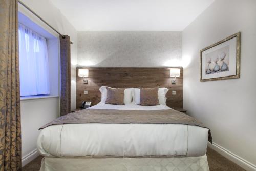 伦敦Hotel Shepherds Bush London的一间卧室设有一张大床和一个窗户。