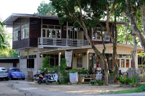 Kampong HuaibūYor Song Hostel Pai的一辆摩托车停在房子前面