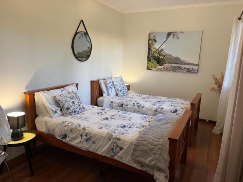 棕榈滩Palm beach Sydney, Modern home with water view的一间卧室设有两张床,墙上设有一面镜子