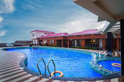 曼达莫尼Prasant Beach Resort的大楼前的大型游泳池