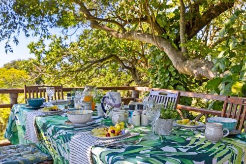 巴利托Seaforth Country House的一张桌子,上面有绿色的白色桌布,上面有水果
