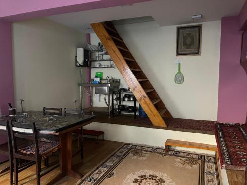 帕坦Kaji Homestay的一间带桌子和楼梯的用餐室