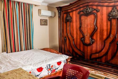 开罗LOVELY PYRAMIDS motel的一间卧室设有木墙,配有一张床