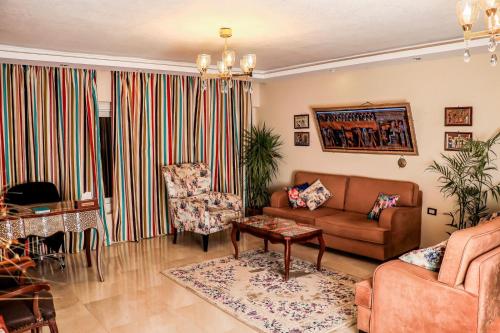 开罗LOVELY PYRAMIDS motel的客厅配有沙发和椅子