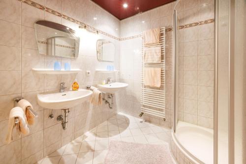 鲁波尔丁Oberaschenauer-Hof的浴室配有2个盥洗盆、淋浴和浴缸。