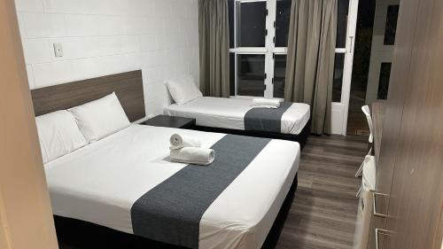 汤斯维尔Townsville City Motel的酒店客房带两张床和一条毛巾