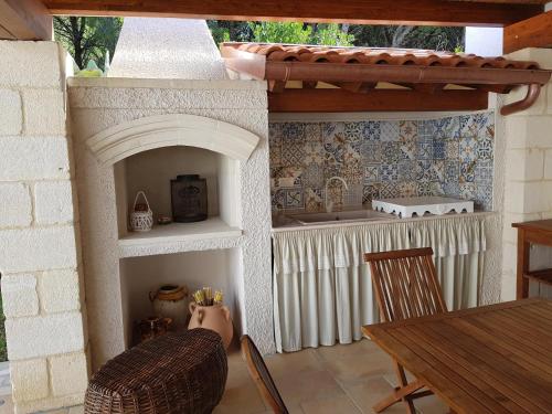 托雷斯佩基亚鲁杰里Villa Maria的一间带炉灶和桌子的厨房(位于客房内)