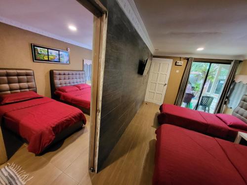 刁曼岛Tamara Guest House的一间设有两张红色床铺和镜子的房间