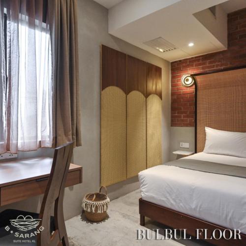 吉隆坡B Sarang Suite Hotel Kuala Lumpur的一间卧室配有一张床、一张书桌和一个窗户。