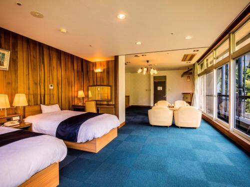 黑部市Yukai Resort Premium Unazuki Grand Hotel的酒店客房,配有两张床和两把椅子