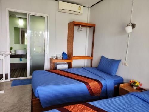 库德岛S海滩度假村的一间带蓝色床的卧室和一间浴室