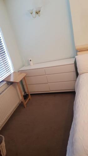伦敦Double bedroom in Raynes Park的客房设有一张床、一张桌子和一个浴缸