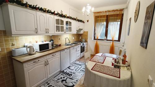 埃格尔Patak apartman的厨房配有白色橱柜和台面