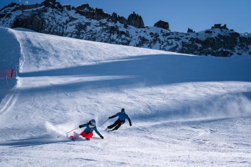科姆梅扎杜拉Affittacamere Sissi的两个人在雪覆盖的斜坡上滑雪