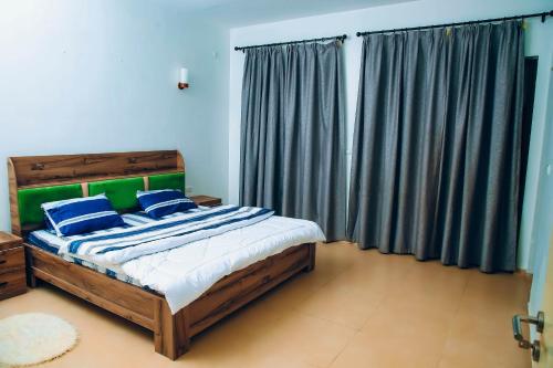 BugeseraSaint Emmanuel near Kigali Convetion center的一间卧室配有一张带蓝色和绿色枕头的床