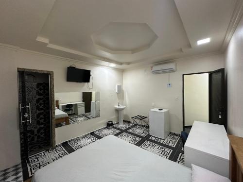 马瑙斯3D Hotel的一间设有床铺和墙上电视的客房
