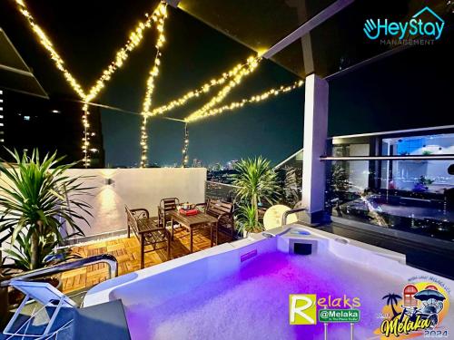 马六甲Imperio Residence By Heystay Management的一个带热水浴缸的庭院,位于一座带灯光的房屋内
