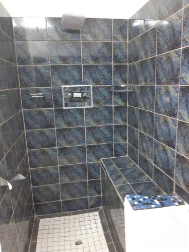 乔治Rosies的浴室设有黑色瓷砖淋浴和卫生间