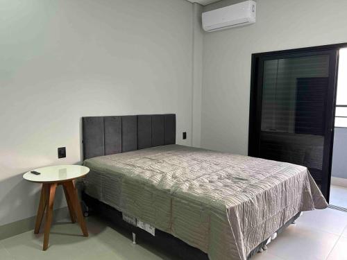锡诺普Studios Mobiliados - Ambar Ipanema的一间卧室配有一张床和一张桌子