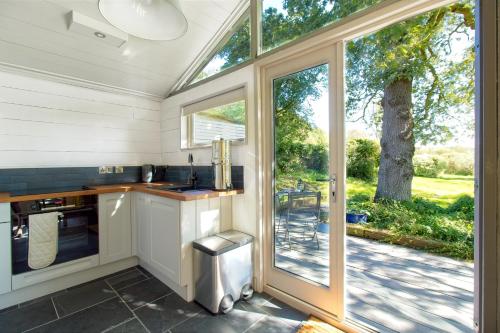 NewtownIsle of Wight Cabin的厨房设有水槽和滑动玻璃门