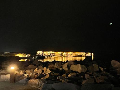 Ytri-NjarðvíkG-1215 apartment的夜间有岩石和码头的水体