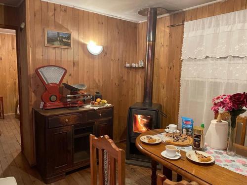 普孔Cabaña Agradable的一间带燃木火炉和桌子的用餐室