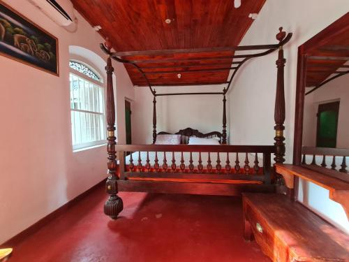 希克杜沃Hill Side Kings Villa (Colonial Bungalow)的一间卧室配有一张大木床。