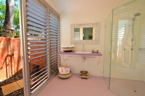 米申海滩思雅拉海滩小屋酒店的浴室配有盥洗盆和带镜子的淋浴