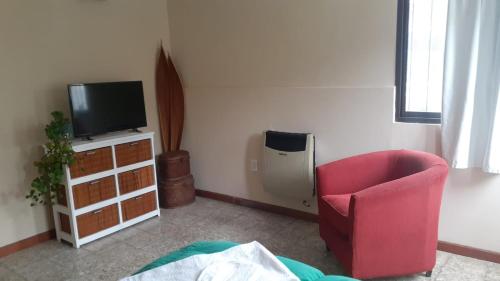 上格拉西亚Loma del Alto的客厅配有红色椅子和电视