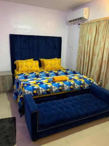 Suru LereJesam House的一张蓝色的床,里面配有黄色枕头