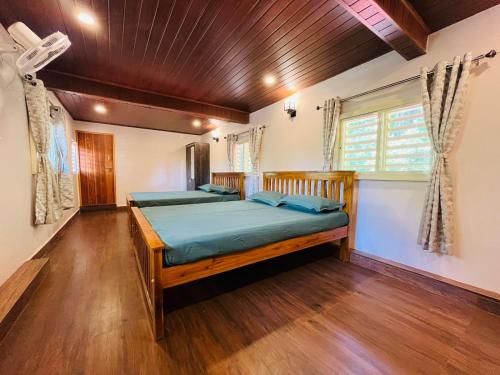 戈卡尔纳GOKARNA JUNCTION - A vintage homestay的一间卧室设有两张床,铺有木地板