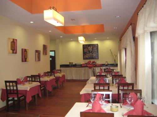 莫卡诺尔Hotel Villa El Mocanal的用餐室配有带粉红色弓的桌椅