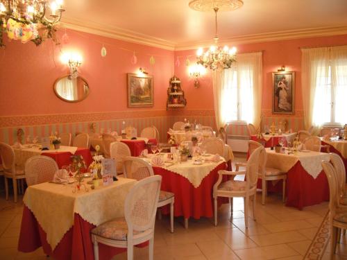 ÉtréaupontHotel Le Clos du Montvinage的一间设有红色和白色桌布的餐桌的用餐室
